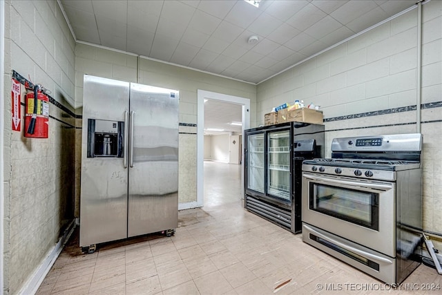 kitchen with tile walls and appliances with stainless steel finishes