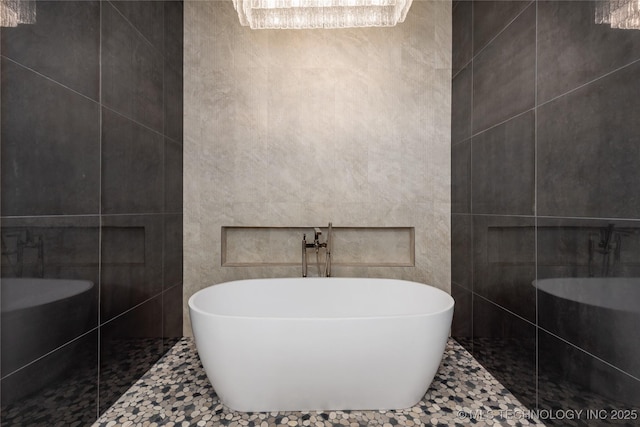 bathroom featuring tile walls, a freestanding tub, a walk in shower, and tile patterned floors