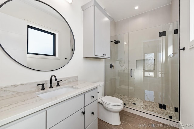 bathroom with vanity, toilet, and a stall shower