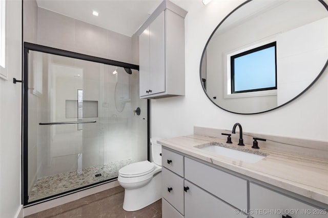 bathroom featuring vanity, toilet, and a shower stall