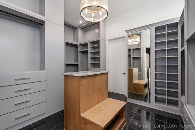 walk in closet with dark tile patterned flooring