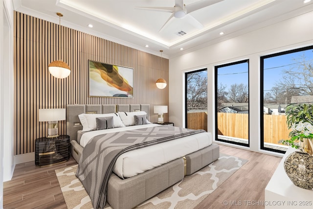 bedroom featuring light wood finished floors, a tray ceiling, recessed lighting, ceiling fan, and access to outside