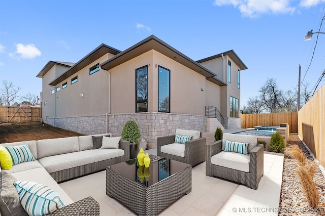 view of patio / terrace with an outdoor living space, an in ground hot tub, and a fenced backyard