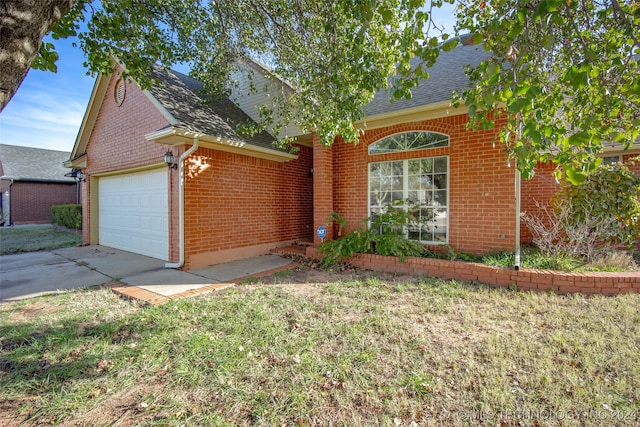 view of front of home with a front yard and a garage