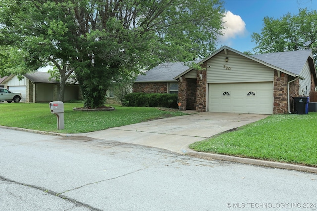 ranch-style home featuring a garage and a front lawn