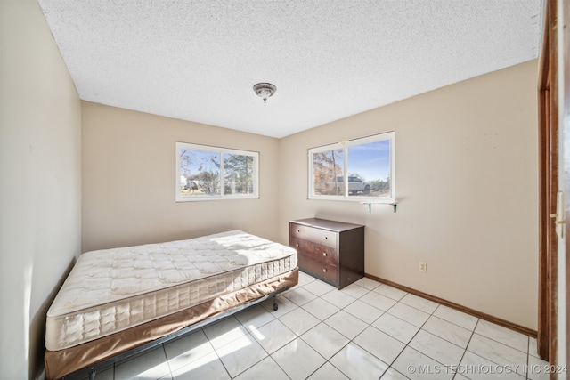 tiled bedroom with a textured ceiling