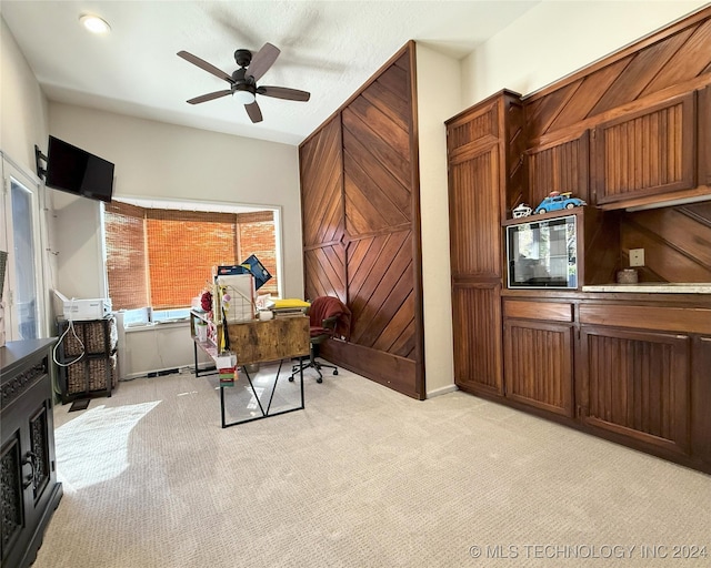 carpeted home office featuring ceiling fan