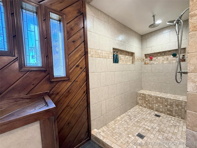 bathroom with wooden walls and tiled shower