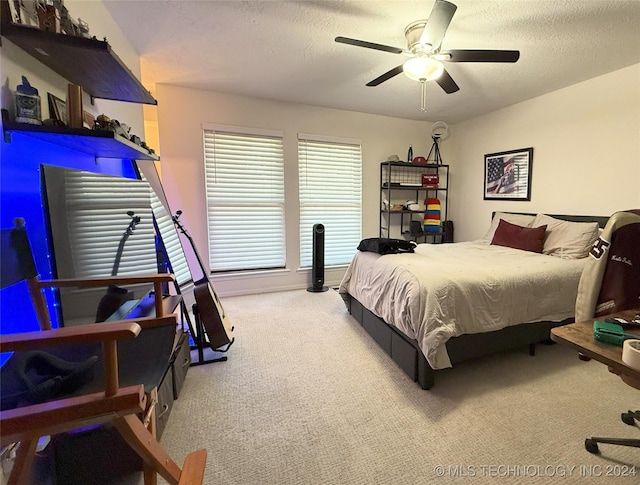 bedroom featuring ceiling fan, carpet floors, and a textured ceiling