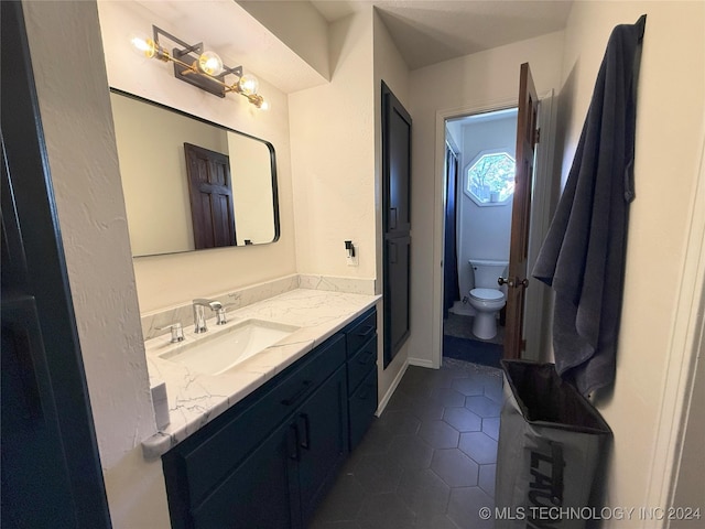 bathroom with tile patterned flooring, vanity, and toilet