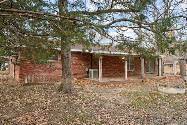 back of property with central AC and a patio