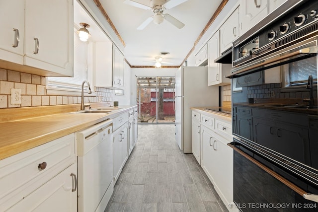 kitchen featuring white appliances, backsplash, crown molding, sink, and white cabinetry