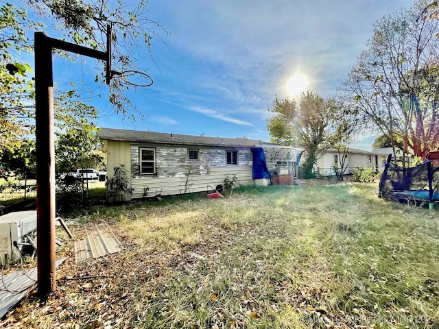 rear view of property featuring a trampoline