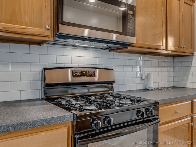 kitchen with appliances with stainless steel finishes and tasteful backsplash