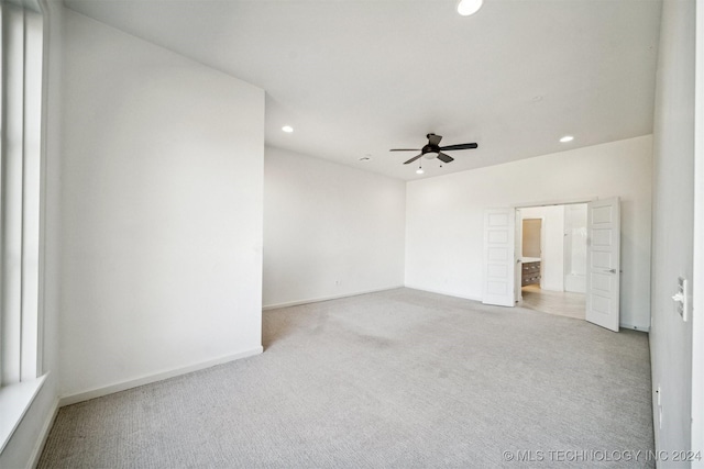 empty room with ceiling fan and light colored carpet