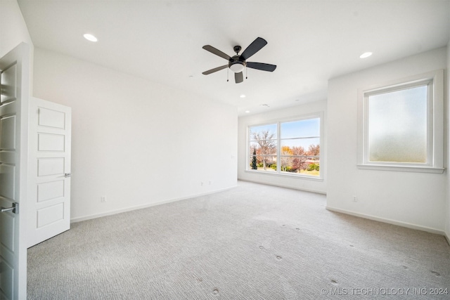 carpeted spare room featuring ceiling fan