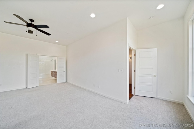 unfurnished bedroom with ceiling fan, light carpet, and ensuite bath