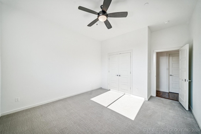 unfurnished bedroom featuring a closet, light colored carpet, and ceiling fan