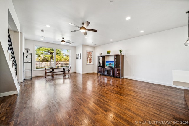 living room featuring ceiling fan and dark hardwood / wood-style flooring