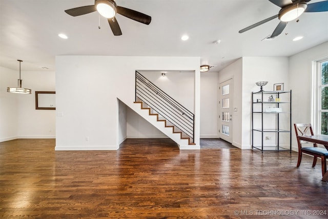 unfurnished living room with dark hardwood / wood-style flooring and ceiling fan