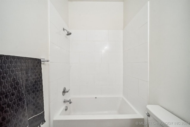 bathroom with tiled shower / bath combo and toilet