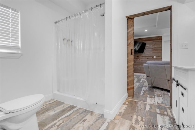 bathroom with hardwood / wood-style flooring and toilet