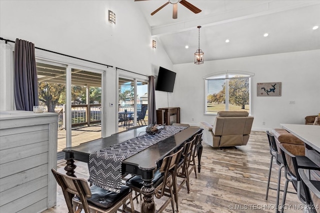 dining room with ceiling fan, beamed ceiling, high vaulted ceiling, and light wood-type flooring