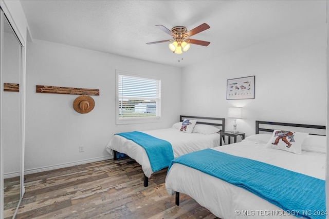 bedroom featuring hardwood / wood-style floors, a closet, and ceiling fan