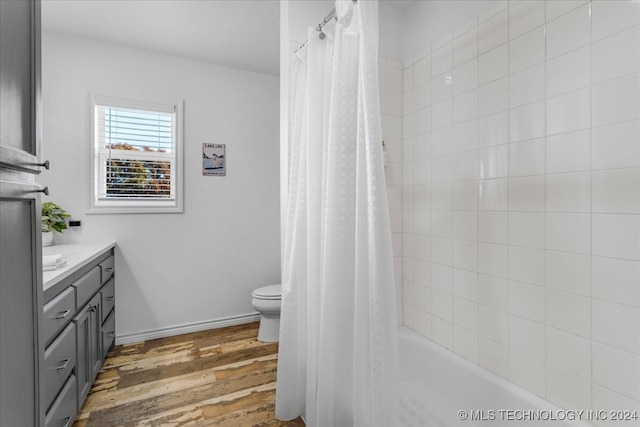 full bathroom with shower / bath combination with curtain, vanity, wood-type flooring, and toilet