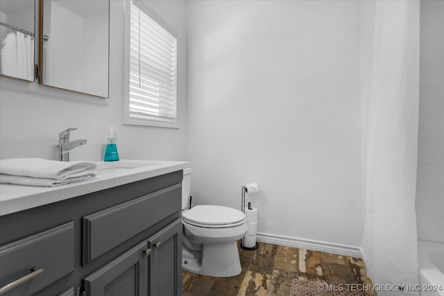 full bathroom with shower / tub combo with curtain, vanity, wood-type flooring, and toilet