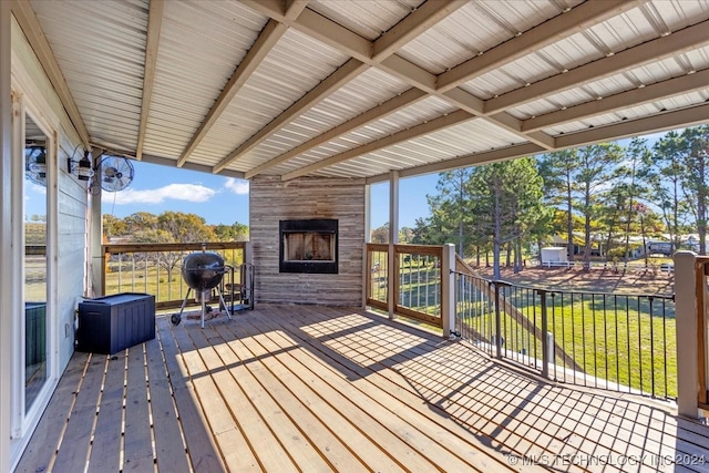 wooden terrace featuring a fireplace and a grill