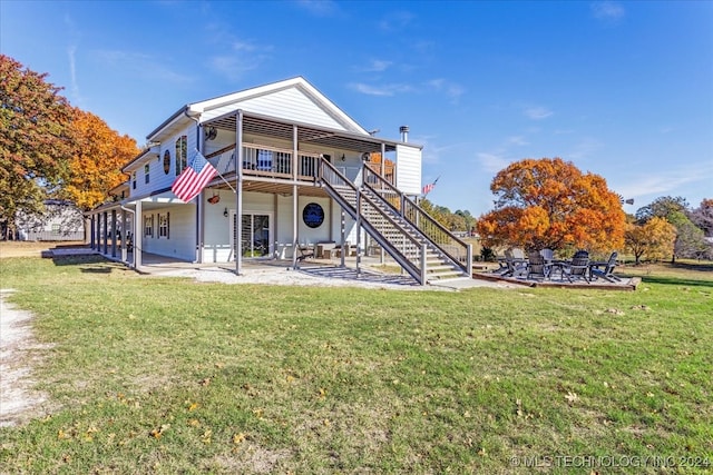 back of property featuring a patio area and a lawn