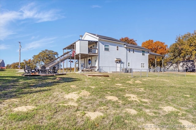 back of house featuring a lawn, central AC, and a balcony