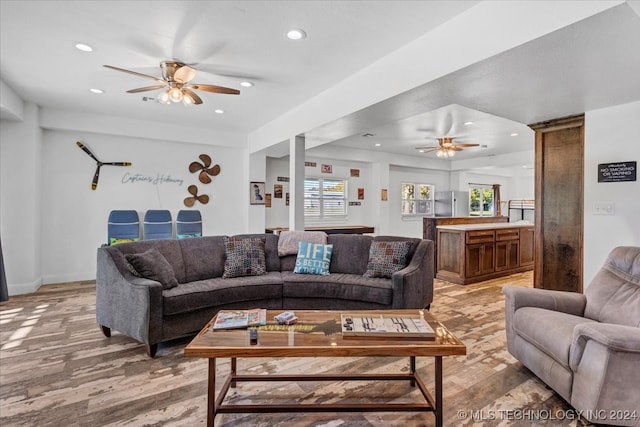 living room featuring ceiling fan and light hardwood / wood-style flooring