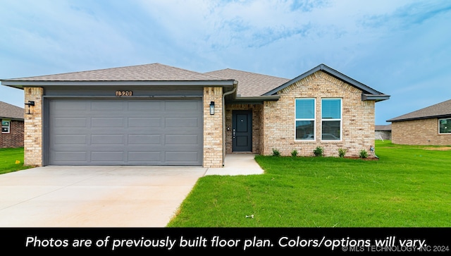 view of front of home featuring a front yard and a garage