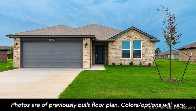 view of front of home with a front yard and a garage