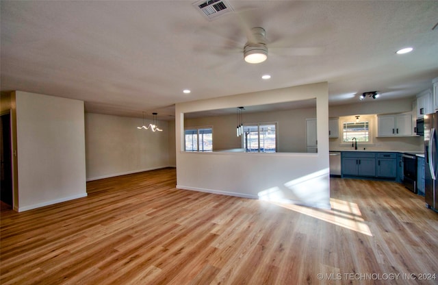 kitchen featuring white cabinetry, light hardwood / wood-style flooring, blue cabinets, ceiling fan with notable chandelier, and appliances with stainless steel finishes