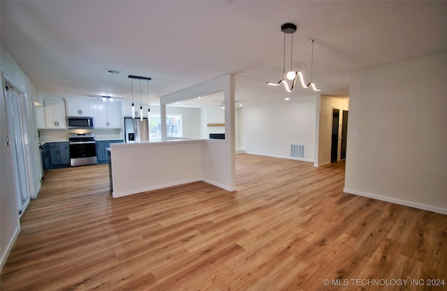 kitchen with white cabinetry, stainless steel appliances, blue cabinets, decorative light fixtures, and light wood-type flooring