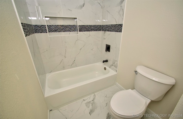 bathroom featuring tiled shower / bath combo and toilet