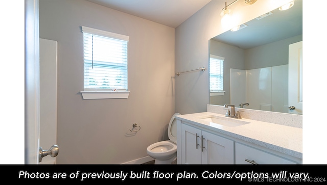 bathroom featuring a shower, vanity, and toilet