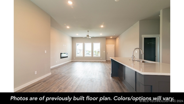 kitchen featuring wood-type flooring, an island with sink, ceiling fan, and sink