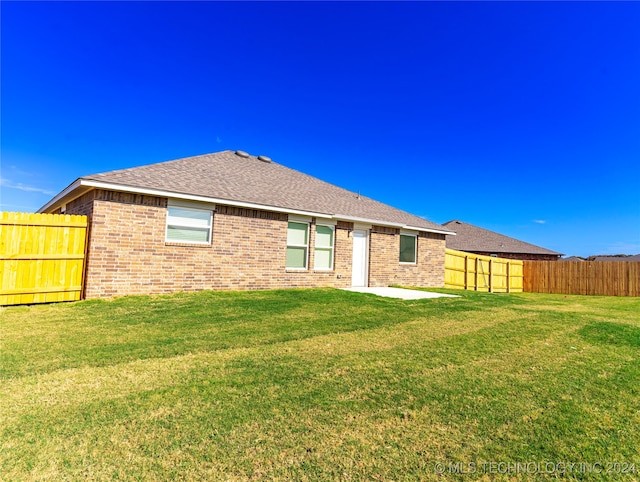 rear view of property with a patio area and a yard