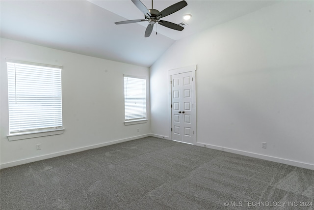 unfurnished room with dark colored carpet, vaulted ceiling, and ceiling fan