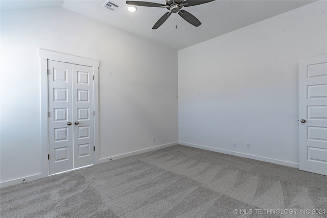 carpeted empty room featuring ceiling fan and lofted ceiling