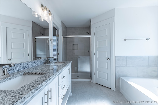 bathroom with vanity, separate shower and tub, and tile walls