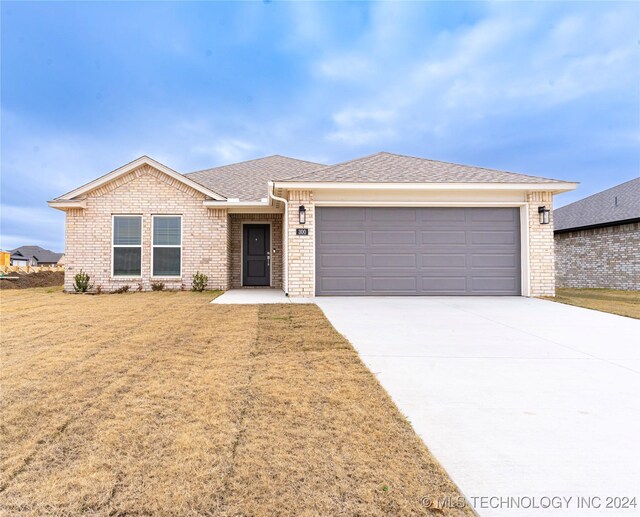 single story home featuring a front lawn and a garage