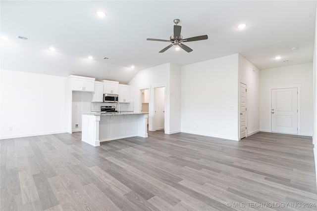 unfurnished living room with ceiling fan, light hardwood / wood-style floors, and lofted ceiling