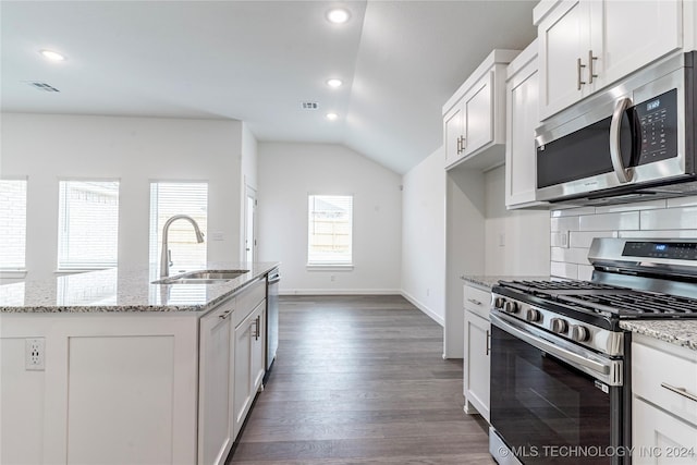 kitchen featuring light stone countertops, appliances with stainless steel finishes, sink, a center island with sink, and dark hardwood / wood-style floors