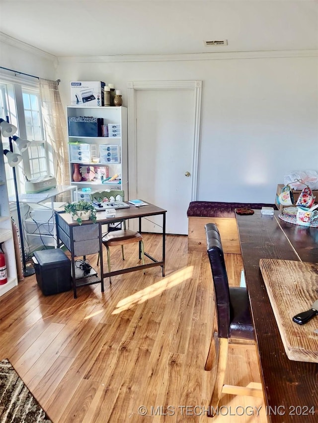 dining area featuring crown molding and light wood-type flooring