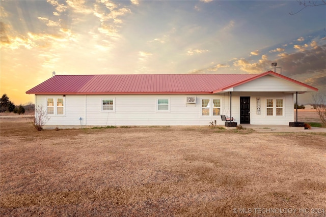 back house at dusk featuring a yard